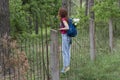 Young beautiful girl with backpack climbing over the fence