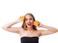 A cheerful girl with a smile holds two halves of an orange at the head level on a white isolated background Royalty Free Stock Photo