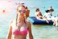 Young, beautiful girl in a bathing suit and sunglasses stands on the background of the sea. The concept of vacation, vacation, Royalty Free Stock Photo