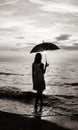 Young beautiful girl on the beach at sunrise with umbrella. Royalty Free Stock Photo