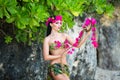 Young beautiful girl in a bikini stands of tropical flowers Royalty Free Stock Photo