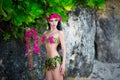 Young beautiful girl in a bikini stands of tropical flowers Royalty Free Stock Photo