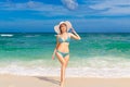 Young beautiful girl in bikini and straw white hat on the beach Royalty Free Stock Photo
