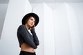 Young beautiful girl in black hat posing over white background. Royalty Free Stock Photo