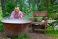 A young beautiful girl, a blonde witch is preparing a potion in a large cauldron on the eve of Halloween or the worshiping devil