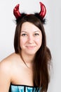 Young beautiful girl in blue corset with red horns looks like pretty Devil Royalty Free Stock Photo