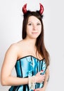 Young beautiful girl in blue corset with red horns looks like pretty Devil Royalty Free Stock Photo