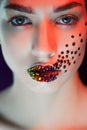 Young beautiful girl with blue eyes. Bright makeup, red lipstick. Art, rhinestones on the lips and face Royalty Free Stock Photo