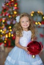 Young beautiful girl in blue white elegant evening dress sitting on floor near christmas tree and presents on a new year Royalty Free Stock Photo