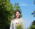 Young beautiful girl with a bouquet of chamomiles. A woman in a barley field Royalty Free Stock Photo