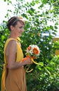 Young beautiful girl bride in a bright orange dress. Summer bouquet in hands of the . Decoration flowers in their hair Royalty Free Stock Photo