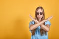 Girl brunette in blue t-shirt over isolated orange background shows emotions