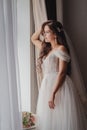 Young beautiful girl a brunette in a white wedding dress. Morning of the brite at the hotel