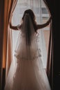 Young beautiful girl a brunette in a white wedding dress. Morning of the brite at the hotel