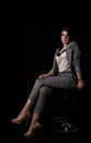 Young beautiful girl in a business suit posing sitting on chair Royalty Free Stock Photo