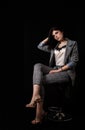 Young beautiful girl in a business suit posing sitting on chair Royalty Free Stock Photo