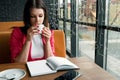 Young beautiful girl, businesswoman drinking tea or coffee sitting in cafe. Business lunch, break Royalty Free Stock Photo