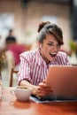 Young beautiful girl at a cafe amazed with laptop content Royalty Free Stock Photo