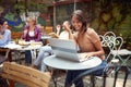 A young beautiful girl is chatting on a laptop while sitting in the bar. Leisure, bar, outdoor Royalty Free Stock Photo