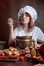 Young beautiful girl in a chef uniform with old pan and wooden Royalty Free Stock Photo