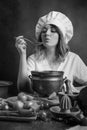 Young beautiful girl in a chef uniform with old pan and wooden Royalty Free Stock Photo