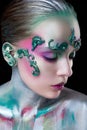 Young beautiful girl with creative make-up of green and purple flowers Royalty Free Stock Photo