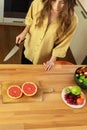 Young beautiful girl is cutting a grapefruit. Royalty Free Stock Photo