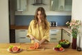 Young beautiful girl is cutting a grapefruit. Royalty Free Stock Photo