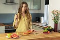 Young beautiful girl is cutting a grapefruit. Royalty Free Stock Photo