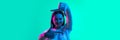 Young beautiful girl demonstrating frame gesture isolated over light green background in neon light. Close-up image