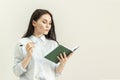 Young beautiful girl with a diary, a notebook and a pen in her hands