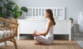 Young beautiful girl doing yoga in lotus position at home Royalty Free Stock Photo