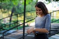 Young and beautiful girl dressed in gray putting on a gold and quartz watch