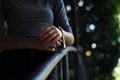 Young and beautiful girl dressed in gray putting on a gold and quartz watch