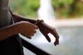 Young and beautiful girl dressed in gray putting on a gold and quartz watch