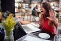 Young beautiful girl enjoying coffee and chat with friend on the laptop Royalty Free Stock Photo