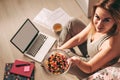 Young beautiful girl enjoying colorful sweets while working from home. A girl looks at the camera and offers candy. concept of Royalty Free Stock Photo