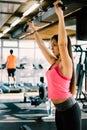 Young beautiful girl exercising in the fitness gym, with lat machine Royalty Free Stock Photo