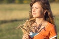 Young beautiful girl in the field with ears in the hand