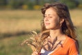 Young beautiful girl in the field with ears in the hand