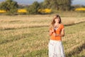 Young beautiful girl in the field with ears in the hand