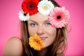 Young beautiful girl with flower in her mouth and her hair. Studio portrait with bright colours. Beauty and youth concept