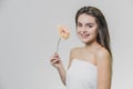 Young beautiful girl with flower in white towel. Girl holding flower in her hand Royalty Free Stock Photo
