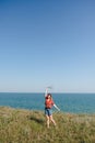 Young Beautiful Girl with Flowers Walking and Dancing on a Beach with smile and joy Royalty Free Stock Photo