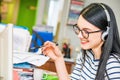 Young beautiful girl with glasses and headphones in office