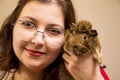 Young beautiful girl in glasses with her cute funny guinea pig Royalty Free Stock Photo