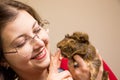 Young beautiful girl in glasses with her cute funny guinea pig Royalty Free Stock Photo