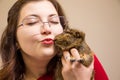 Young beautiful girl in glasses with her cute funny guinea pig Royalty Free Stock Photo