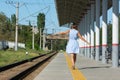 Young beautiful girl goes on the platform holding her arms outstretched to the side Royalty Free Stock Photo