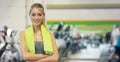 Young beautiful girl in the gym, stands smiling with a towel on her shoulder after the coaching and relaxed. Concept: to love spor Royalty Free Stock Photo